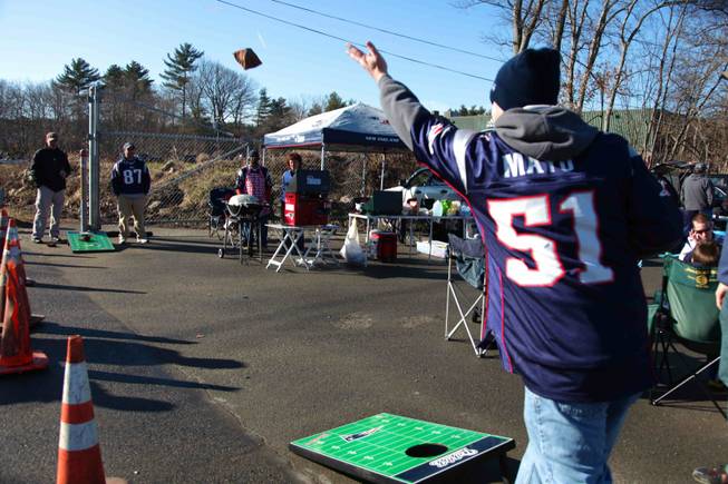 Todd Alperin, a season-ticket holder, plays beanbags in a tailgating across the highway outside Gillette Stadium. He drives down from New Hampshire for games and looks forward to having a casino and the "fun atmosphere" it would bring.
